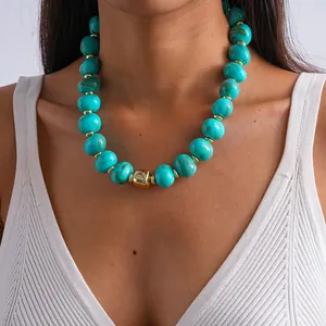 Dettaglio di una collana vintage con perle in acrilico turchese marmorizzato su una modella