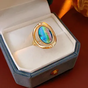 Detailed view of a vintage gold open ring with iridescent stone inside a jewelry box
