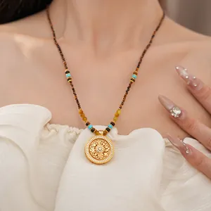Detailweergave van 24k vergulde bloemenhanger met kralenketting van natuursteen.