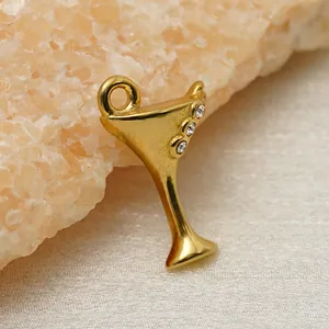 Detailed shot of a gold-plated martini glass charm with three small crystals