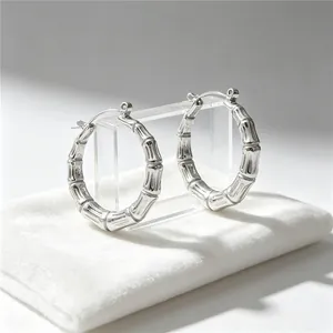 Detailed macro shot of silver bamboo joint hoop earrings displayed on a white velvet pouch
