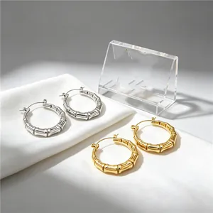 Close-up detail of stylish bamboo joint hoop earrings in gold and silver finishes