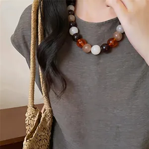 Detail shot of dopamine acrylic beaded necklace in earthy tones for beach holiday style