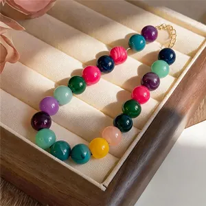 Close-up of vibrant multi-colored acrylic beaded necklace in a luxury wooden display box