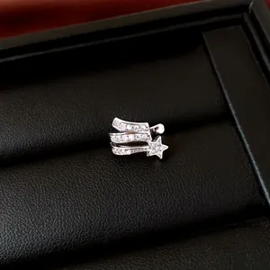 Detail view of a silver-tone star ear cuff with sparkling zircon inlay in a black box.