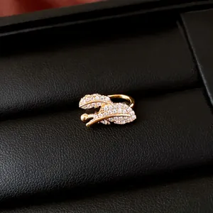 Detailed macro shot of super shiny zircon leaf ear cuff in elegant gold finish jewelry