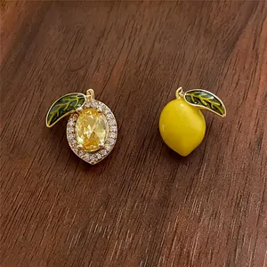 Detailed view of 14k gold plated lemon earrings with yellow crystal and green enamel