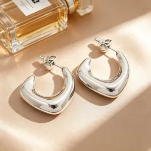 Vue macro de boucles d'oreilles créoles en acier inoxydable en U avec fini poli miroir