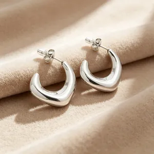 Vue macro de la finition polie des boucles d'oreilles en acier inoxydable en forme de U.