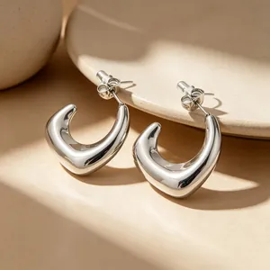Gros plan détaillé de boucles d'oreilles en acier inoxydable en forme de U avec fini argent poli