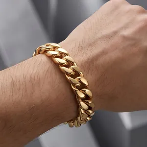 Primer plano de una pulsera de eslabones cubanos de acero dorado en la muñeca de un hombre.