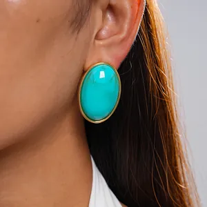 Close-up of retro oval marbled turquoise acrylic earrings with gold bezel