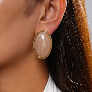 Detailed close-up showing retro marbled acrylic oval stud earrings with gold trim
