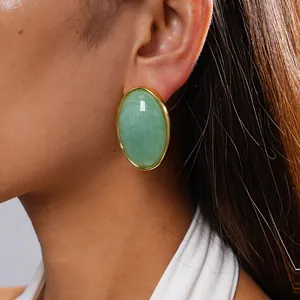 Detail close-up of a vintage green marble acrylic oval stud earring on a model's ear