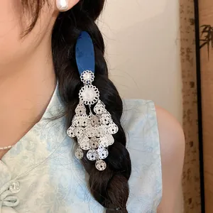 Detailed view of vintage blue flower tassel hair clip worn in a dark hair braid