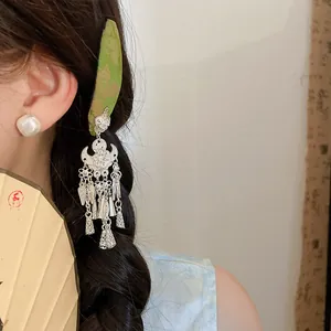Detail view of retro silver flower hair clip with tassel and bell charms for Hanfu