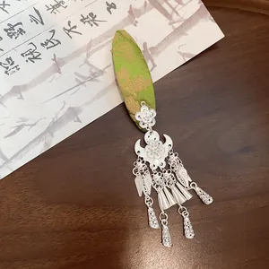 Detailed view of vintage silver flower tassel hair clip with green brocade