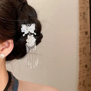 Close-up detail of silver vintage butterfly hair clip with floral tassels on braided hair