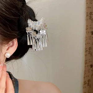 Close-up of vintage butterfly hair clip with silver tassels on dark hair