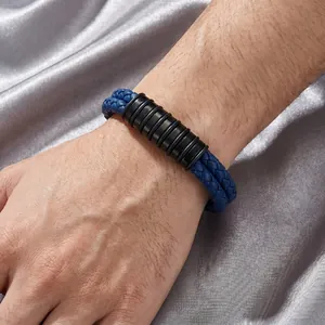 Détail d'un bracelet en cuir bleu pour homme avec des perles en métal noir rainurées.