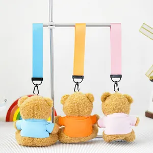 Vista trasera de tres lindos llaveros de ositos de peluche con camisetas de colores.