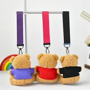 Vista detallada de tres lindos colgantes de ositos de peluche con camisetas moradas, rojas y negras