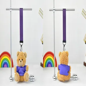 Detalle de un bonito llavero de peluche de osito marrón con una pequeña camiseta lila