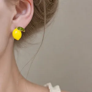 Elegant 14k gold plated lemon enamel stud earring displayed on a female model's ear