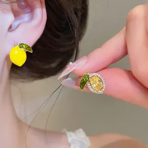 Detailed macro view of asymmetric 14k gold plated lemon earrings with yellow zircon