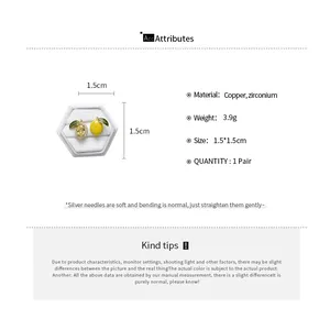 Detailed view of asymmetrical lemon stud earrings with zirconium and enamel finishes.