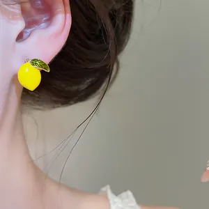 Detailed view of a 14k gold plated enamel lemon stud earring featuring a vibrant yellow finish