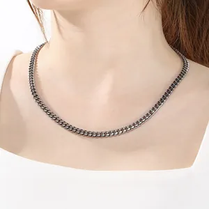 Detailed view of a sleek stainless steel Cuban link necklace worn on a person's neck