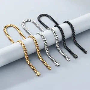 Detail of polished stainless steel Cuban link necklaces in gold, silver, and black.