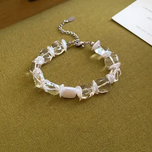 Gros plan détaillé d'un bracelet en perles de verre transparentes avec intercalaires blancs