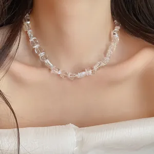 Gros plan d'un collier élégant en perles de verre transparentes sur le cou d'un mannequin