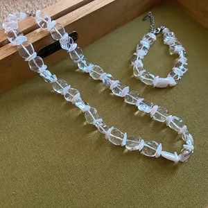 Vue détaillée des perles de verre transparentes et des perles blanches du set de bijoux