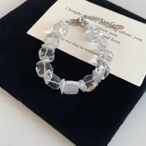 Vue détaillée d'un bracelet en perles de verre transparent avec intercalaires blancs.