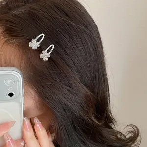 Nahaufnahme von funkelnden Strass-Glücksklee-Haarspangen auf braunem Haar