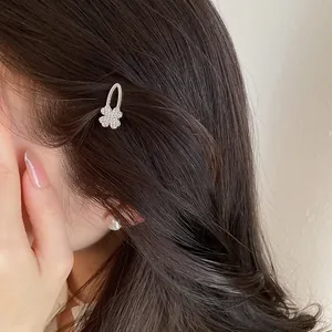 Eleganter glitzernder Kleeblatt-Haarclip auf dunklem Haar für Styling