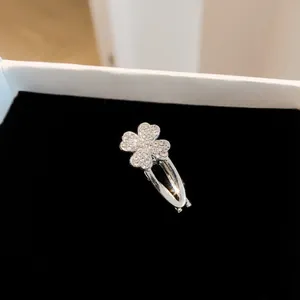 Detailgetreue Makroaufnahme einer glitzernden Strass-Vierklee-Haarklammer auf Samt