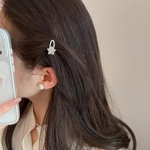 Detailansicht einer eleganten silbernen Stern-Haarklammer mit Strass auf dunklem Haar