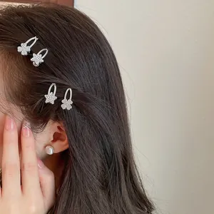 Nahaufnahme von glitzernden Stern- und Kleeblatt-Haarspangen, die am Haar des Models gestylt sind