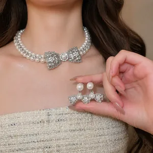 Elegante set di collana e orecchini a fiocco vintage francese con zirconi e perle lucide