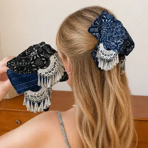 Elegante haarklem met stoffen strik en zilveren kwastjes in een vintage stijl voor dames