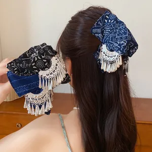 Detailweergave van vintage stoffen haarklemmen met etnische prints en zilveren kwastjes