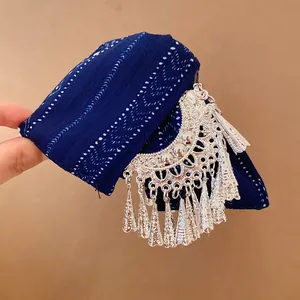 Detail van een vintage blauwe stoffen haarklem met zilveren kwastjes en franje