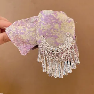Detail van vintage haarklem met zilveren kwastjes en paarse brokaatstof voor dames