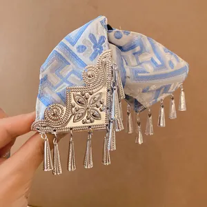Detail van vintage blauw bedrukte haarklem met zilveren bloemen en kwastjes versiering