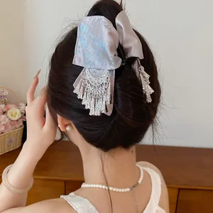 Detailopname van vintage haarklem met lavendel bloemenstrik en metalen kwastjes