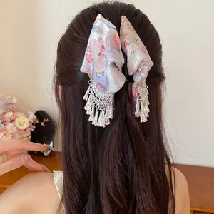 Vintage haarklem met bloemenprint, stoffen strik en elegante zilveren kwastjes